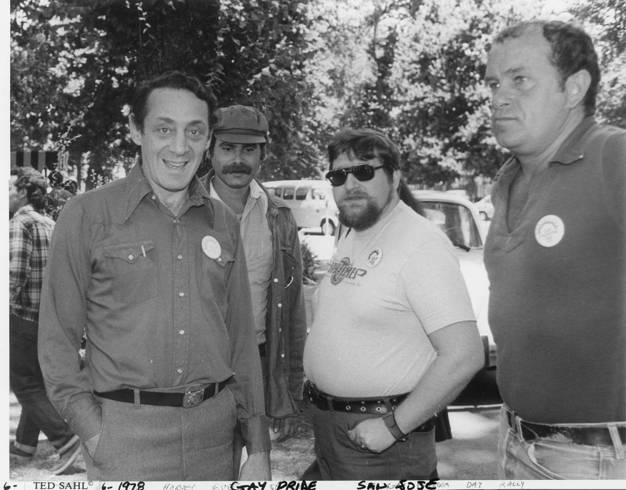 Harvey Milk, left, and three other men pictured at Gay Pride in San Jose, California in 1978. "6-1978 Harvey goes to Gay Pride San Jose."—written on sleeve holding photograph.