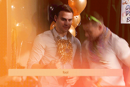 Gif 2: An orange gradient gif from 3x18. It is May's graduation party and there are balloons in the background. Buck and Eddie are at the photobooth with a fake guitar and necklaces on them. Buck makes a motion that causes his necklace to hit Eddie as the camera flashes. Eddie makes a silly face as Buck checks on him. The overlayed image is a single orange gradient rectangular box that says "fool".