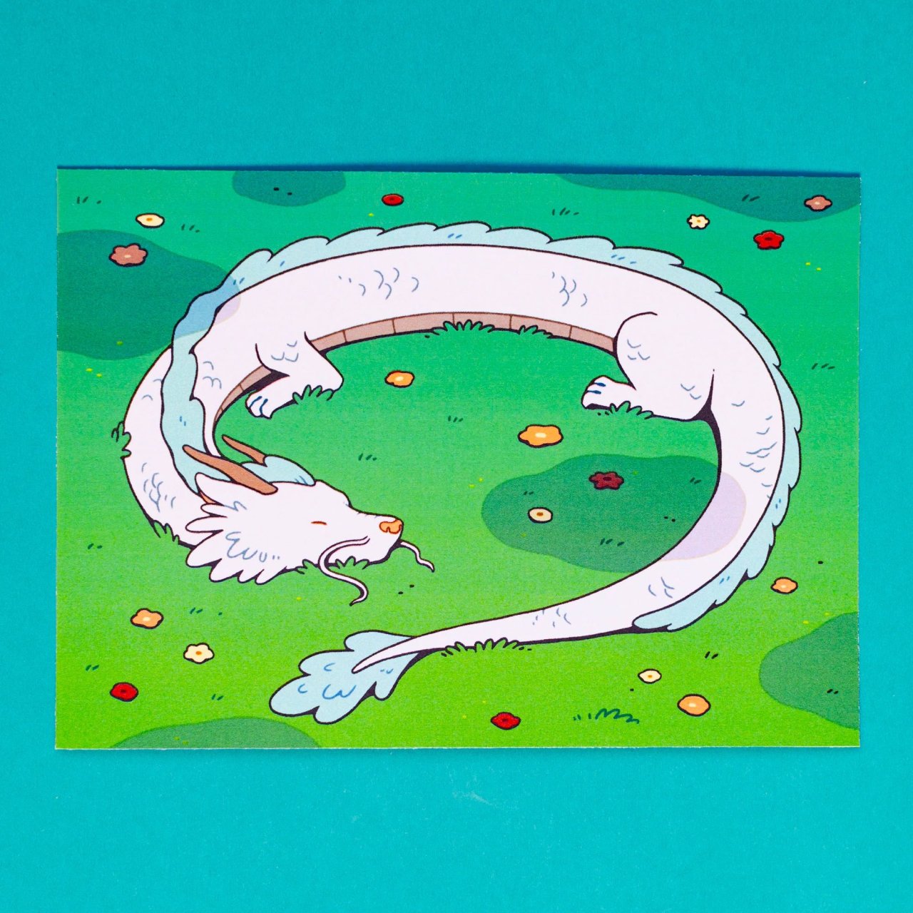 Art print depicting a Chinese dragon curled up in a meadow, surrounded by small wildflowers.