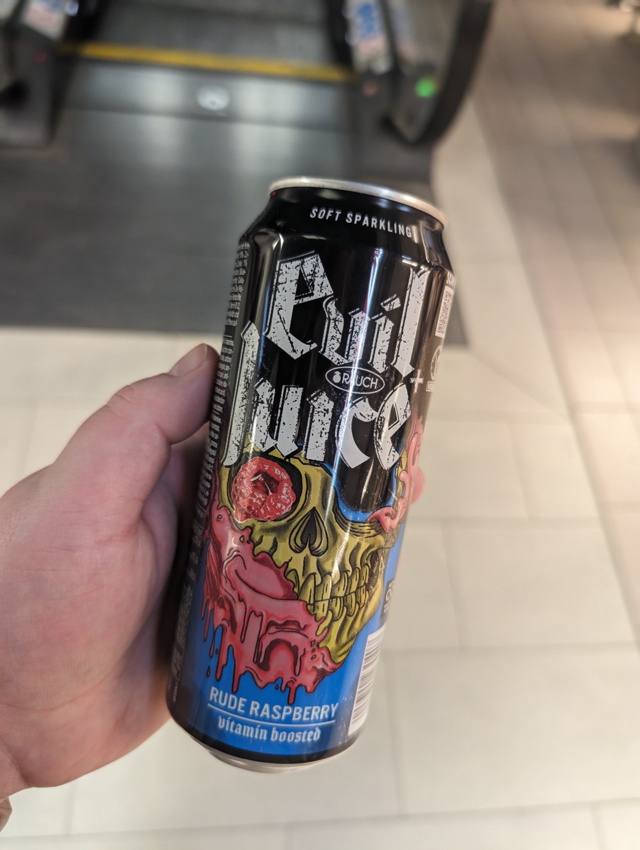 a photo of a drink can in my hand, the drink is called "evil juice, rude raspberry"