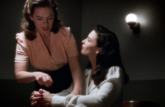 gif 3 of 7. Dottie looks at Peggy with interest while she talks.