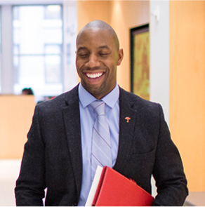 Business person smiling and carrying a red folder.