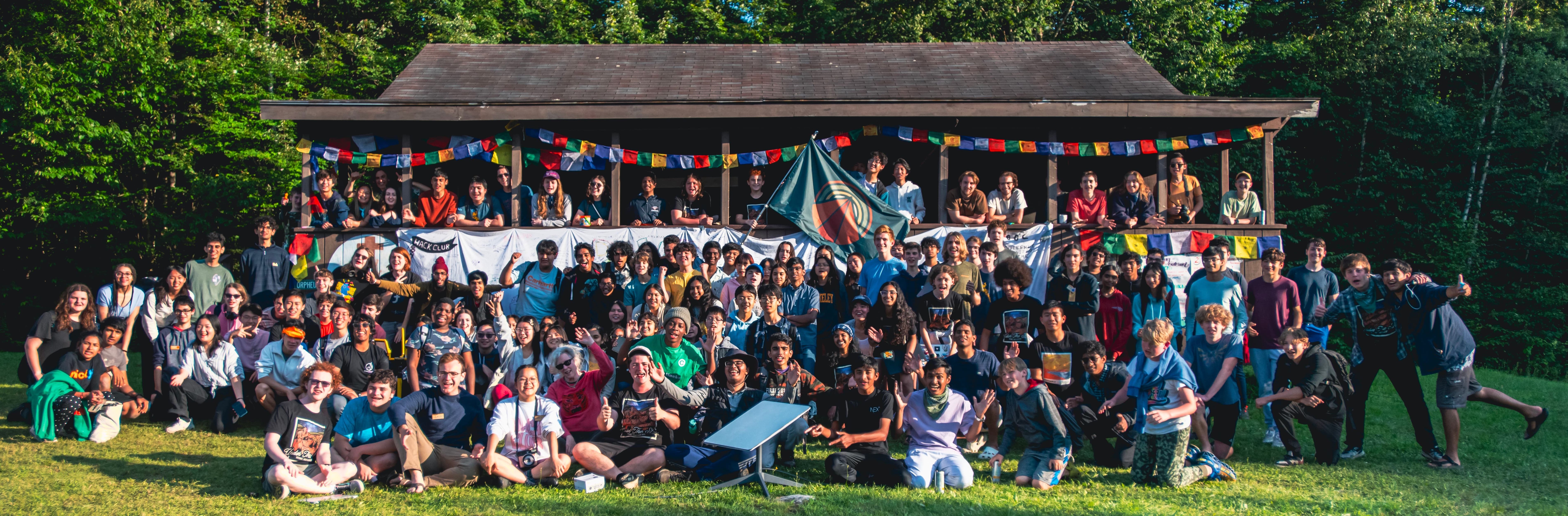 A group photo of Hack Clubbers in front of a cabin