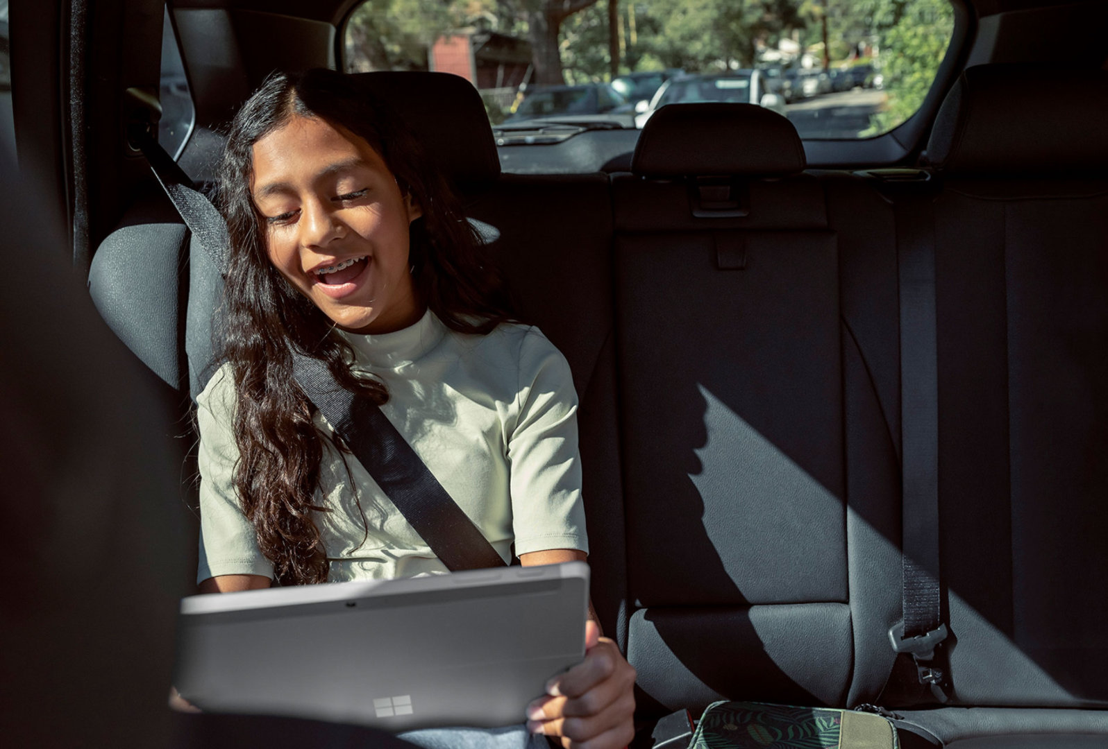 小孩在車裡使用 Surface Go 3。