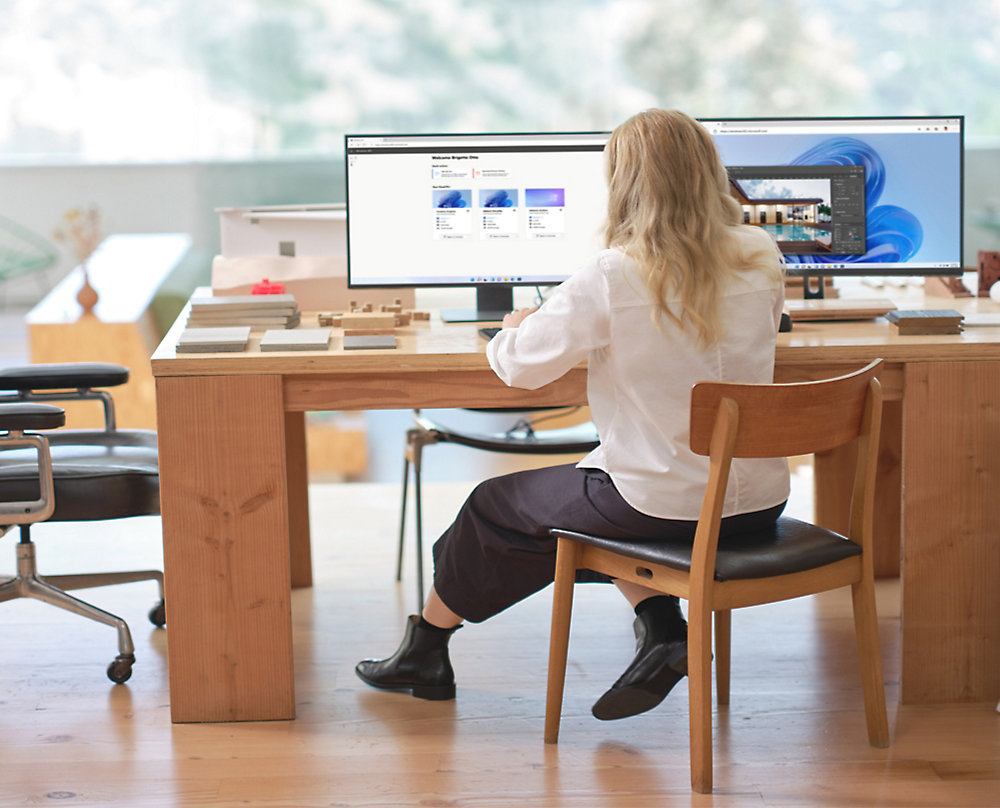 En person, der sidder ved et skrivebord og kigger på en computer