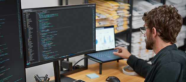 軟體開發人員在雙顯示器工作站上撰寫程式碼。
