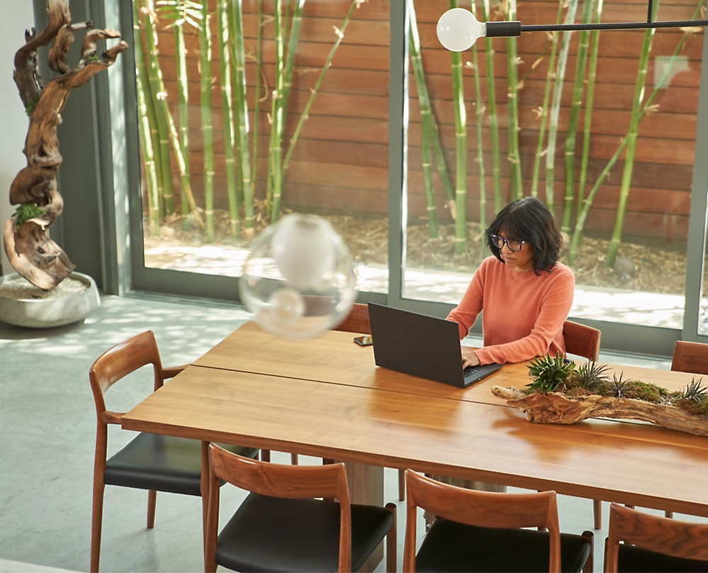 En person, der sidder ved et bord og bruger en bærbar computer
