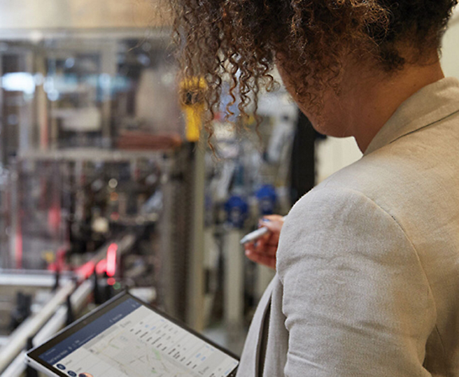 Γυναίκα που παρακολουθεί βιομηχανικές διεργασίες σε ψηφιακό tablet.