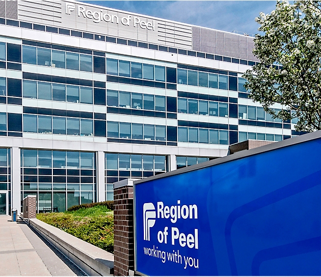 Pohled z venku na kancelářskou budovu Region of Peel s nápisem „Region of Peel working with you“ v popředí