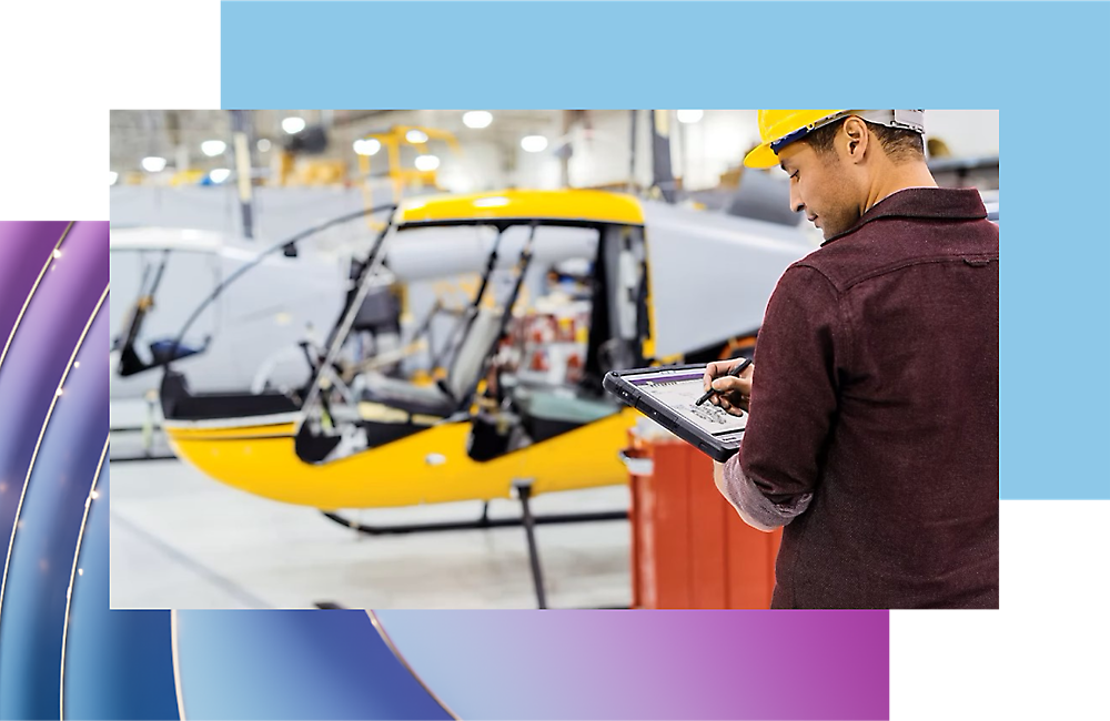 Εργαζόμενος που ελέγχει την πρόοδο βιομηχανικής παραγωγής αεροσκάφους με ένα ψηφιακό tablet σε ένα υπόστεγο.