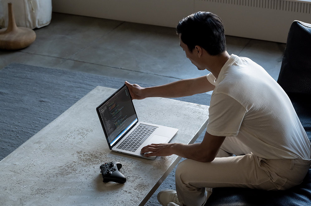 有人使用採用膝上型電腦模式的 Surface Laptop Studio，在客廳編碼。