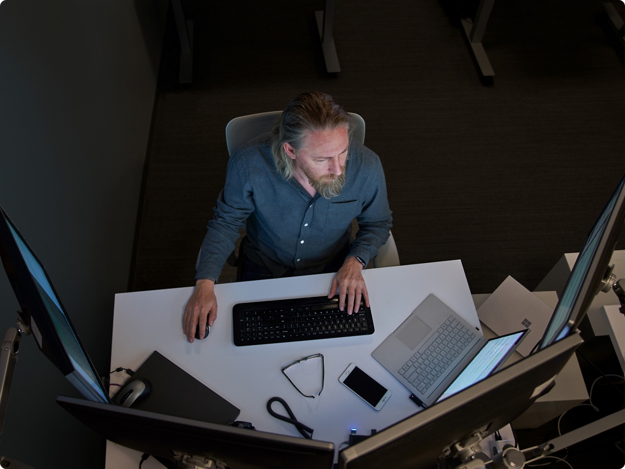 Zwei Männer, die sich auf einen Computerbildschirm in einer Büroumgebung konzentrieren, einer stützt sein Kinn auf der Hand.