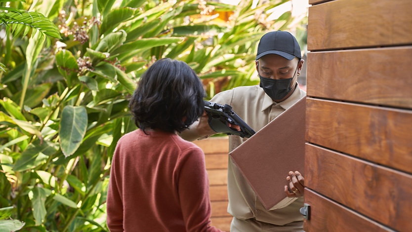 A person receiving a package from a delivery person.