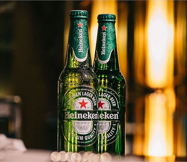 Dwie butelki piwa marki Heineken stoją na stole.