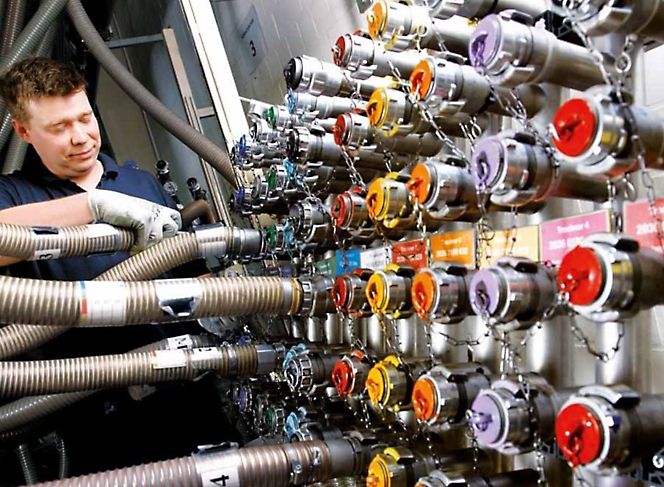 Ένας άνδρας εργάζεται σε μια μηχανή με πολλούς διαφορετικούς χρωματιστούς σωλήνες.