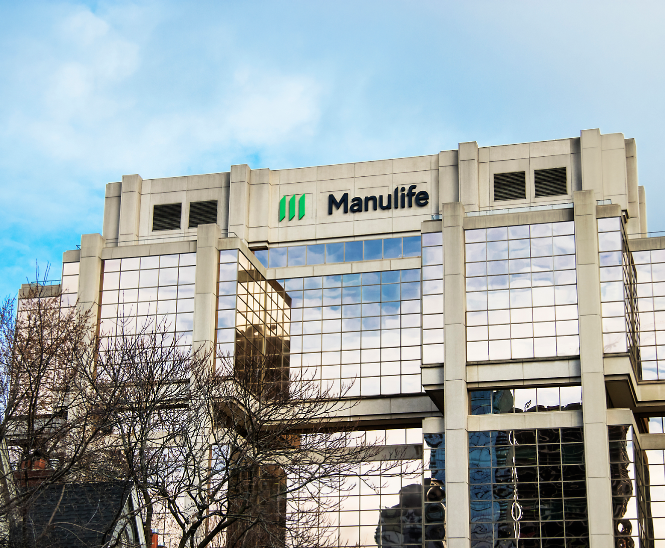 Exterior view of the manulife building with its logo, showcasing reflective glass windows and a modern architectural design.