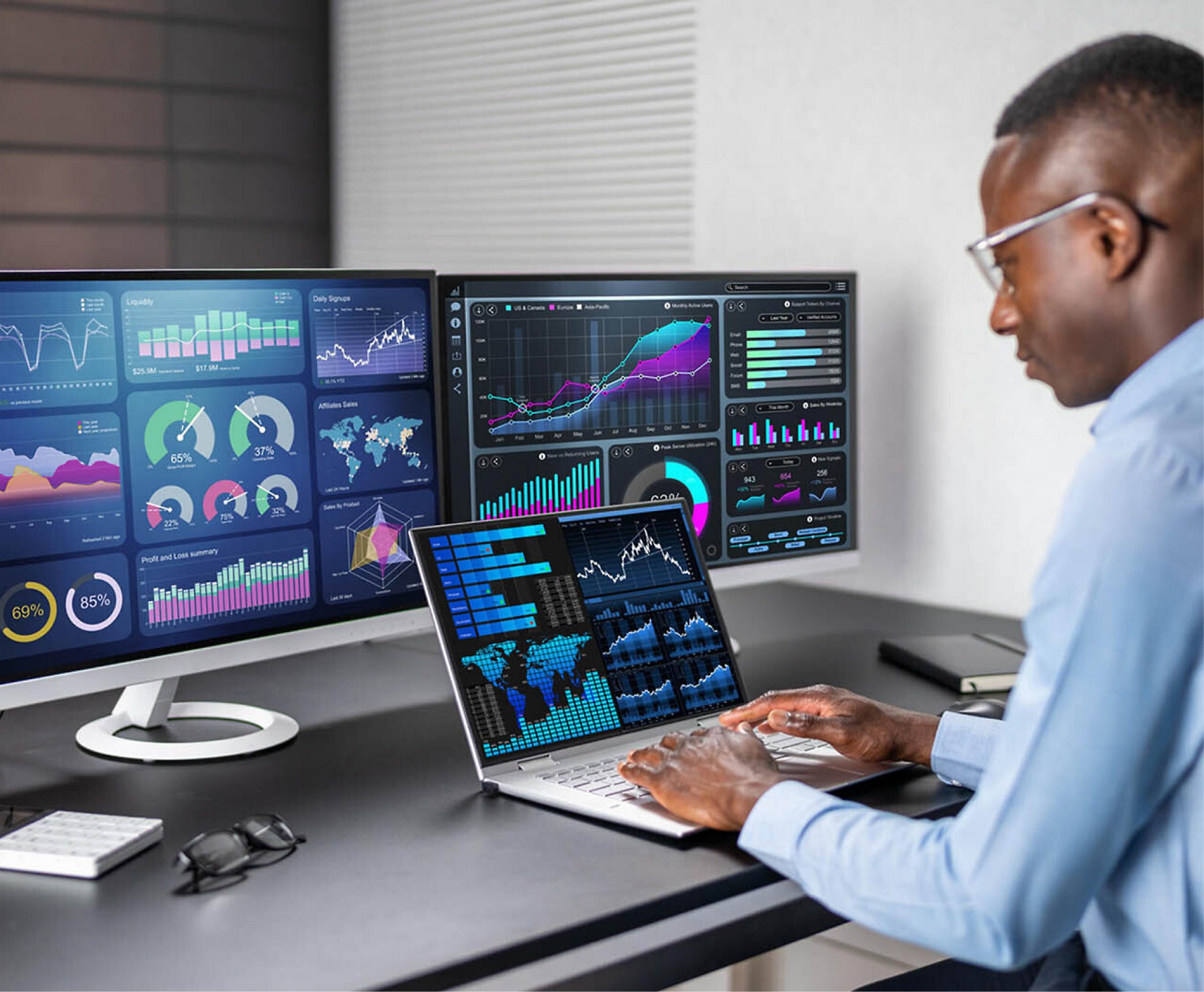 Een man analyseert financiële gegevens op meerdere computerschermen in een moderne kantooromgeving.