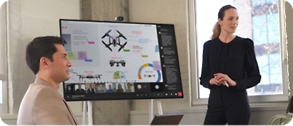 Teams 会議中に Microsoft Surface Hub 2S でデータを提示する女性