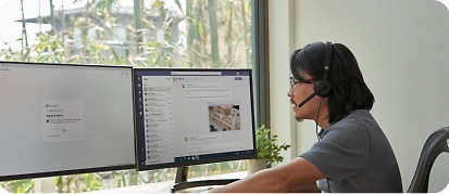 En man som arbetar på distans från sitt hemmakontor vid ett skrivbord med dubbla bildskärmar och mobila enheter