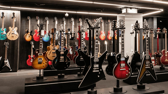 Många gitarrer visas i en butik.