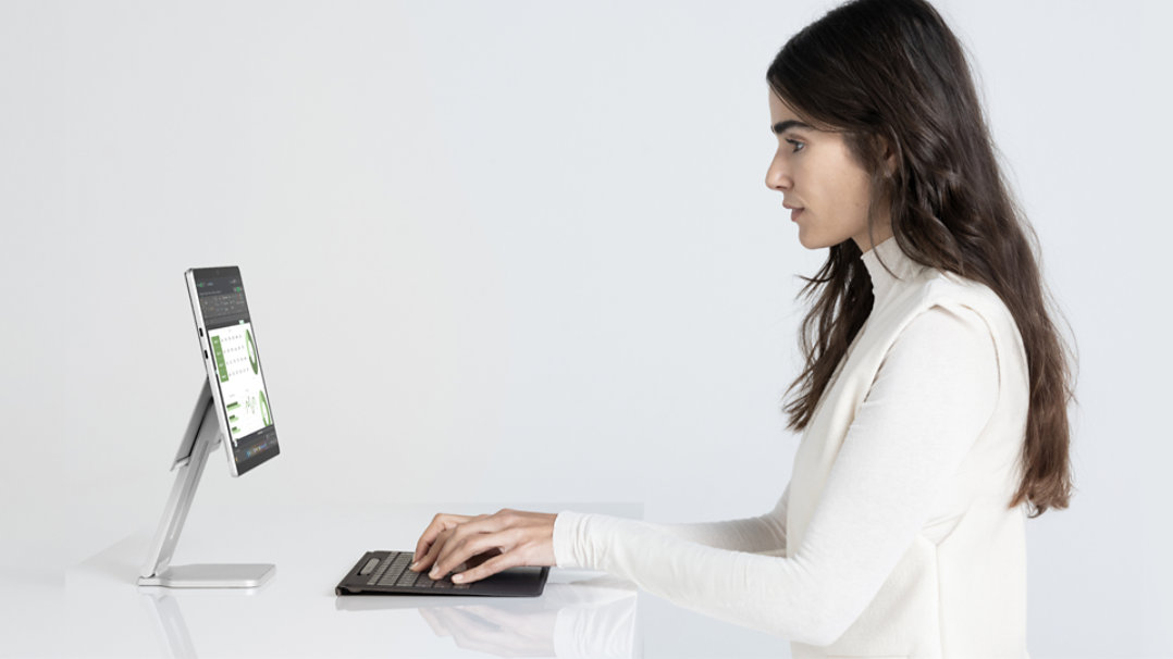 Imej seorang wanita bekerja dengan papan kekunci Surface Pro Flex, yang ditanggalkan daripada Surface Pro dalam mod tablet.