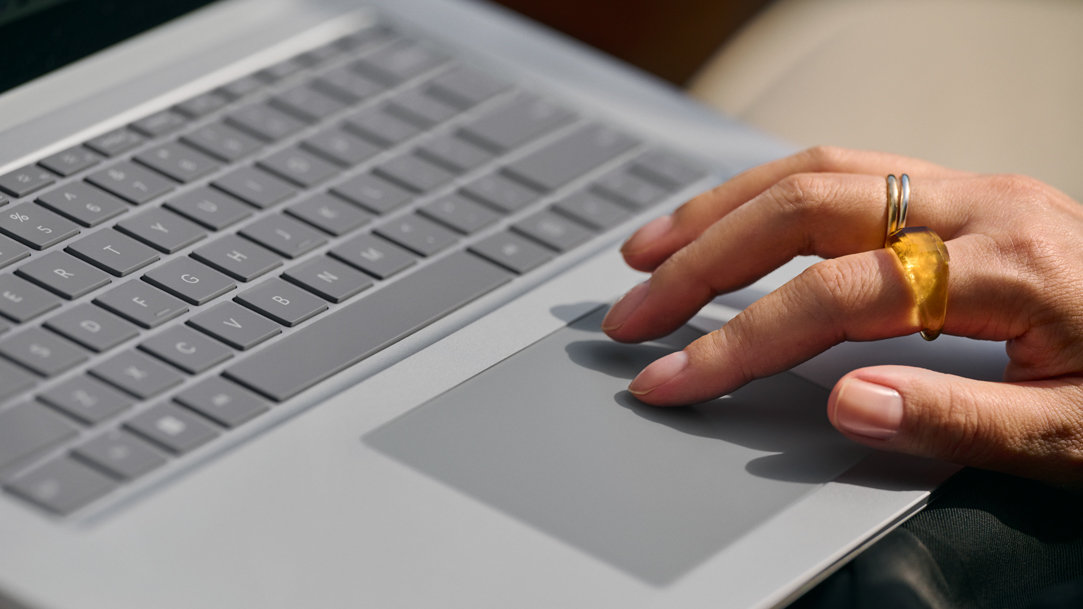 Hand with rings types on a Surface Laptop 5 keyboard