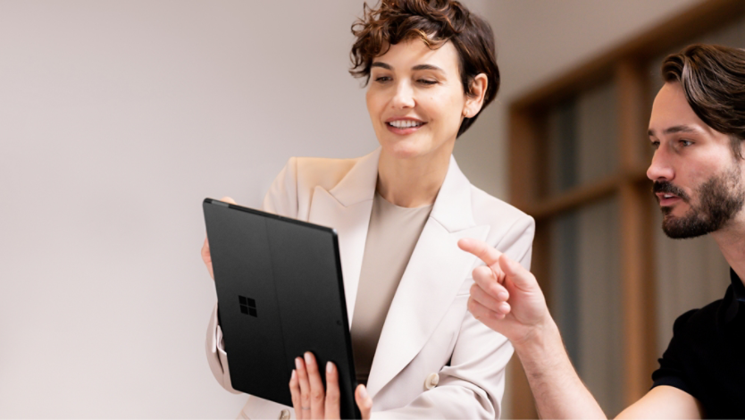 Wanita dan Lelaki melihat Surface Pro 10 dalam mod tablet