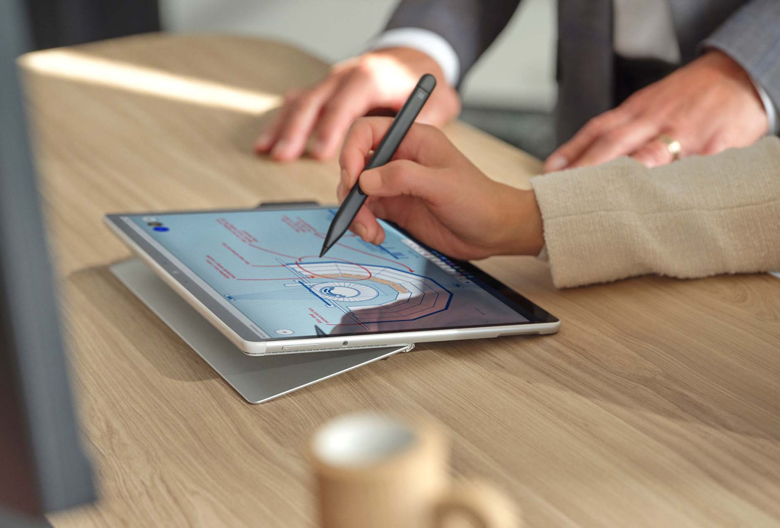 De hand van een persoon met Surface Slim Pen 2 op het scherm van Surface Pro 8