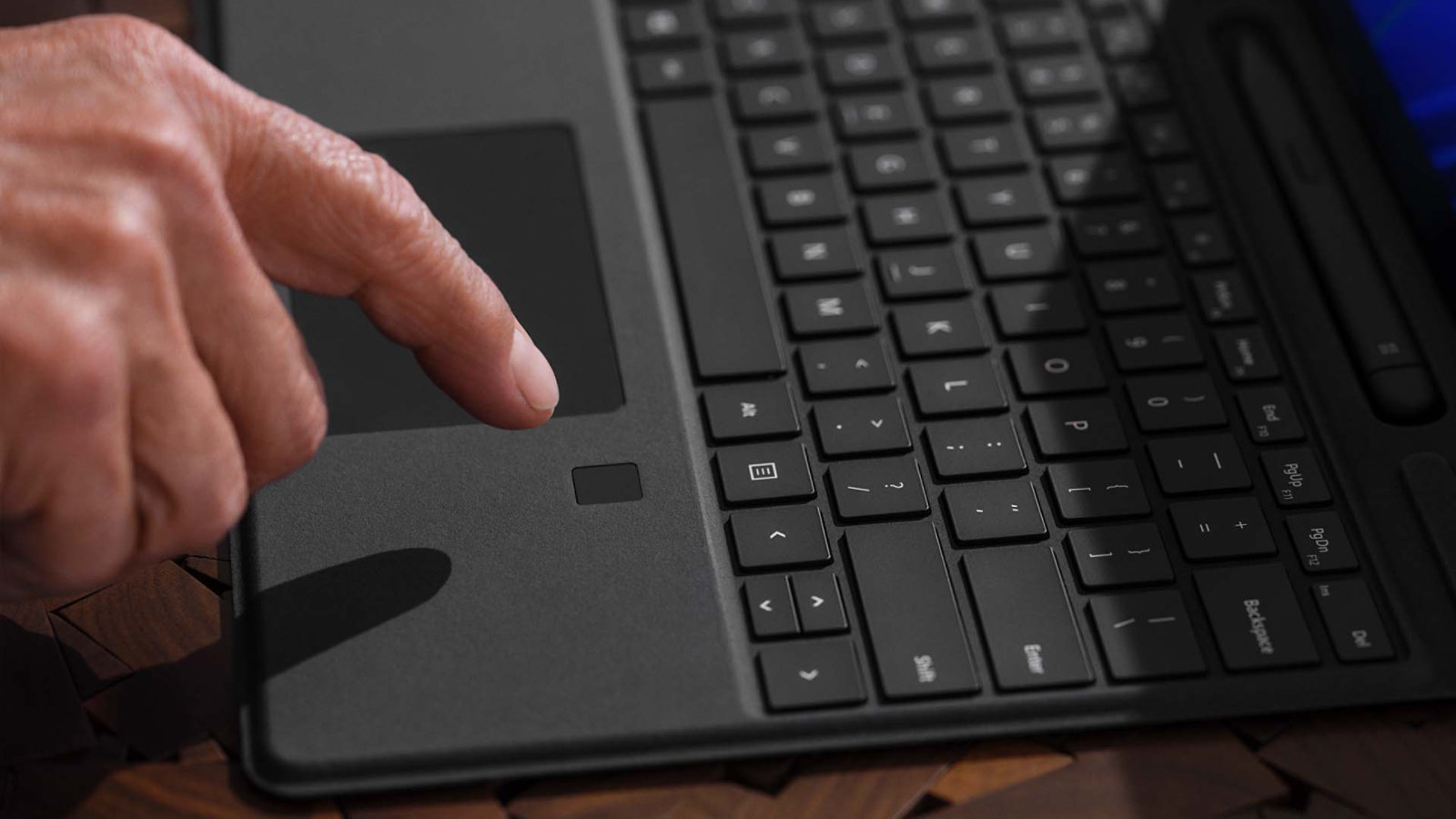 นิ้วของคนคนหนึ่งลอยอยู่เหนือฟีเจอร์การลงชื่อเข้าใช้ด้วยเทคโนโลยีชีวมาตรบน Surface Pro Signature Keyboard