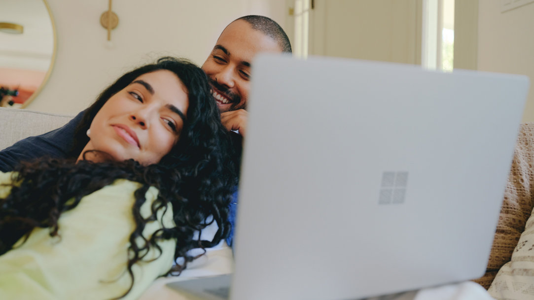 Two people looking at Surface device