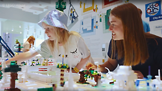 カラフルな LEGO の構造物を組み立てている 2 人。