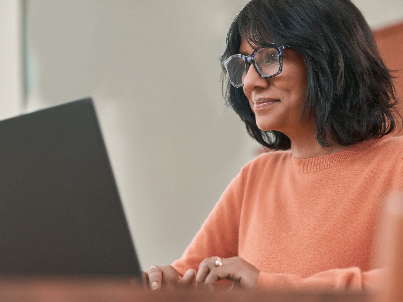 Μια γυναίκα με γυαλιά που εργάζεται με φορητό υπολογιστή