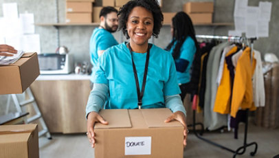A young volunteer holding a box marked donate