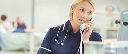 Uma enfermeira a falar ao telefone num hospital.