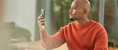 Um homem está a tirar uma fotografia com o seu telemóvel.