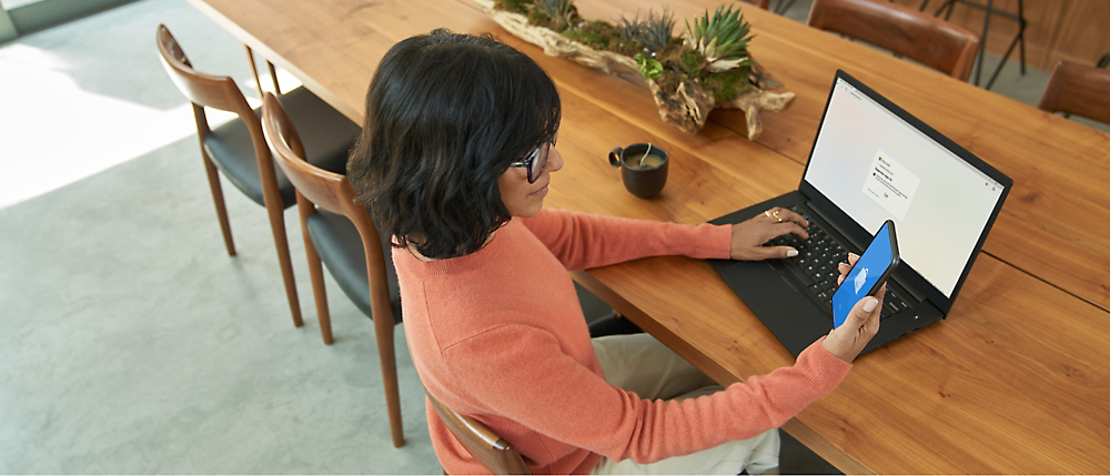 Pessoa sentada usando um computador sobre uma mesa