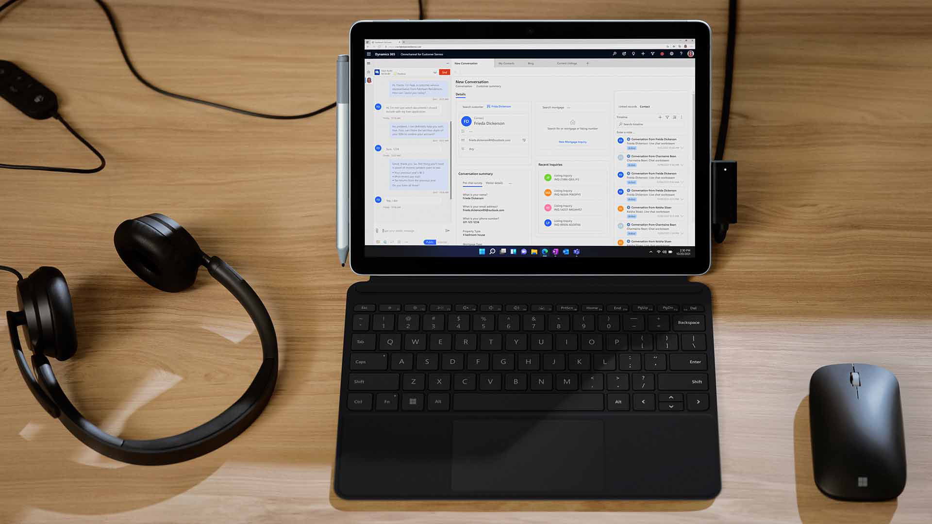 Surface Go 4 im Laptop-Modus auf einem Tisch mit Surface-Kopfhörern und Surface Mouse