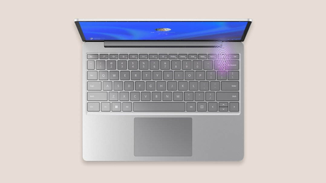 Bovenaanzicht van een platina Surface Laptop Go 3 met de vingerafdruklezer verlicht in de rechterbovenhoek van het toetsenbord.