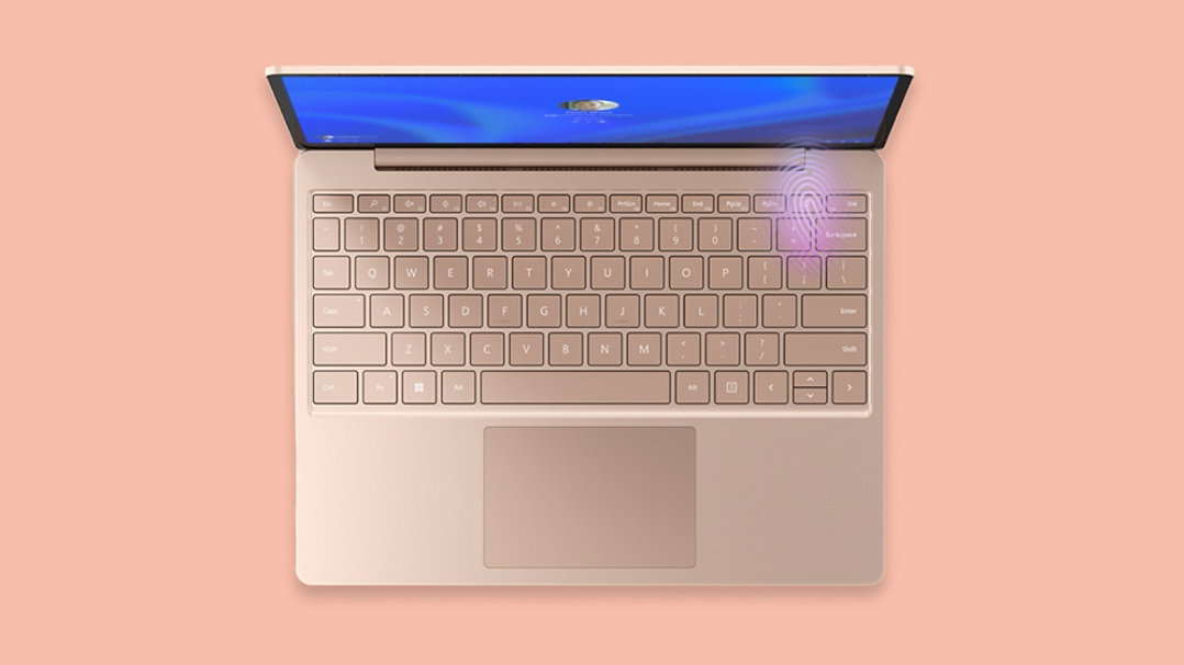 Top view of sandstone Surface Laptop Go 3 with the fingerprint reader illuminated in the top-right corner of the keyboard.