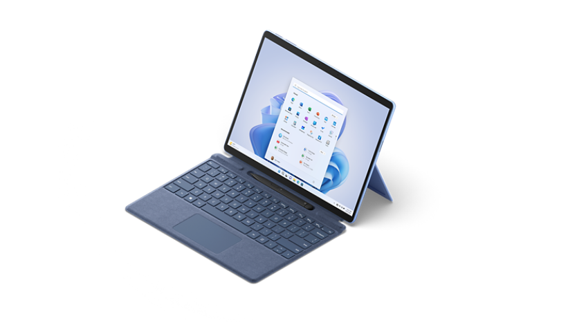 زاوية عرض 3/4 من الأعلى للابتوب Surface Pro 9 باللون أزرق ياقوتي، مع لوحة مفاتيح Surface Type Cover مرفقة.