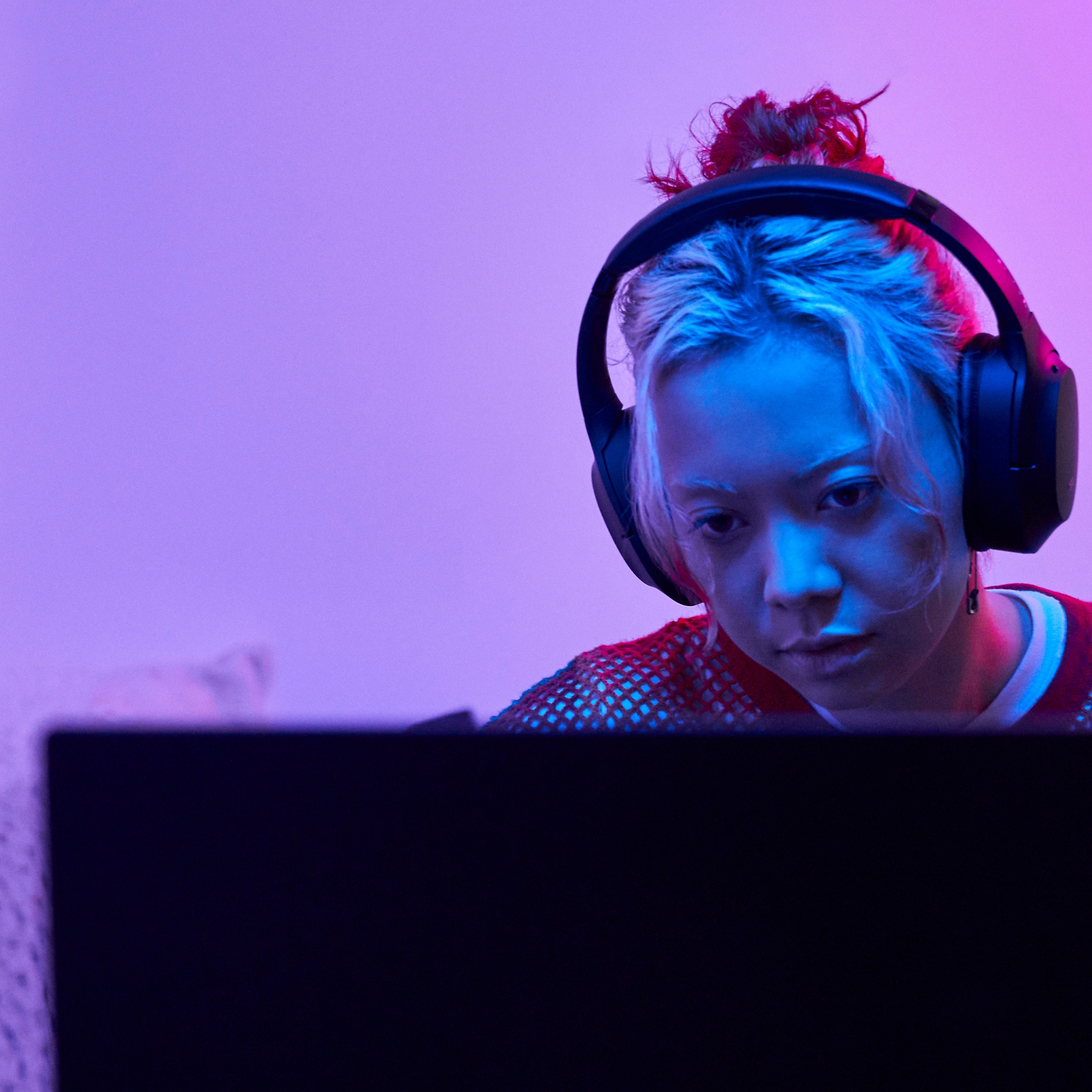 En kvinde, der arbejder på en bærbar computer med hovedtelefoner