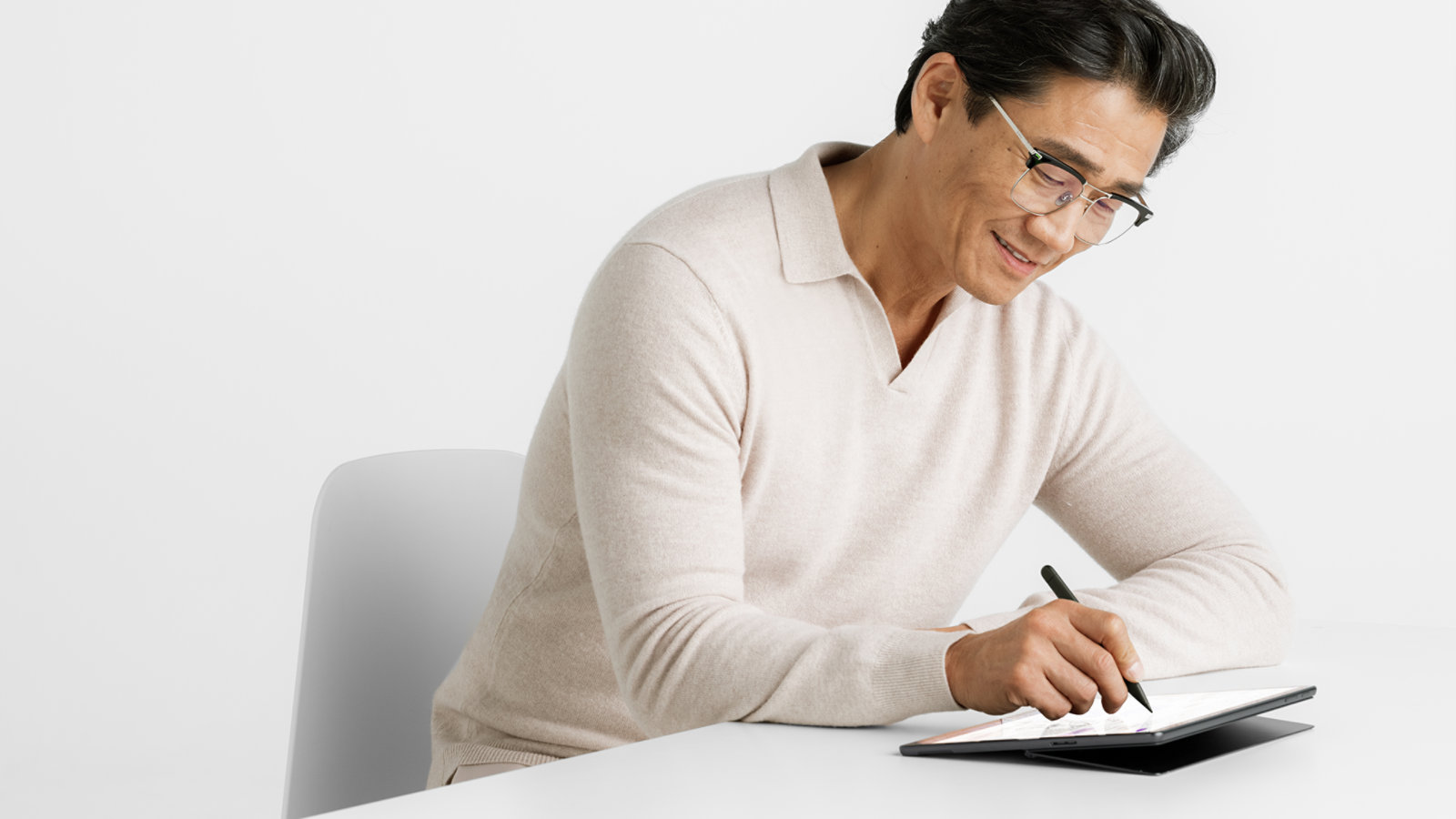 Una persona usa un Surface Slim Pen para empresas para escribir en la pantalla táctil de un dispositivo Surface Pro 10 para empresas.