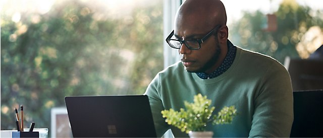 Um homem olhando para um laptop