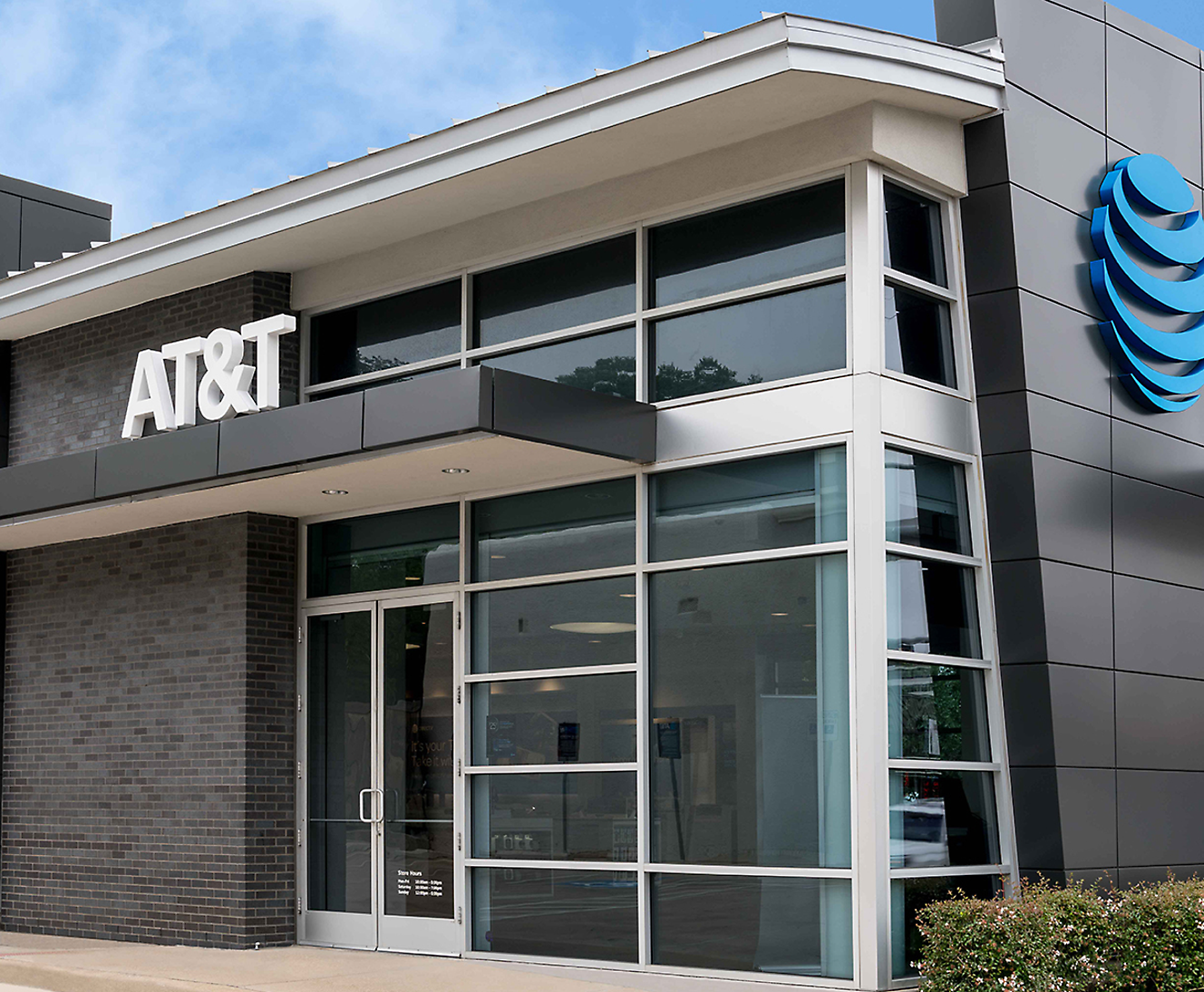 Exterior view of an AT&T store with glass windows and a prominent AT&T logo on the building.