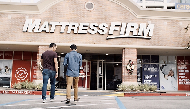 Deux hommes se tenant devant un magasin Mattress Firm.