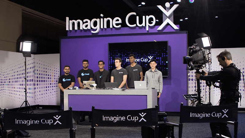 Sechs Imagine Cup-Teilnehmer, die an einem Tisch stehen und gefilmt werden