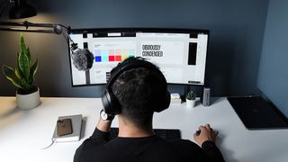 A UI designer uses one of the best UI design tools on a monitor screen on a desk