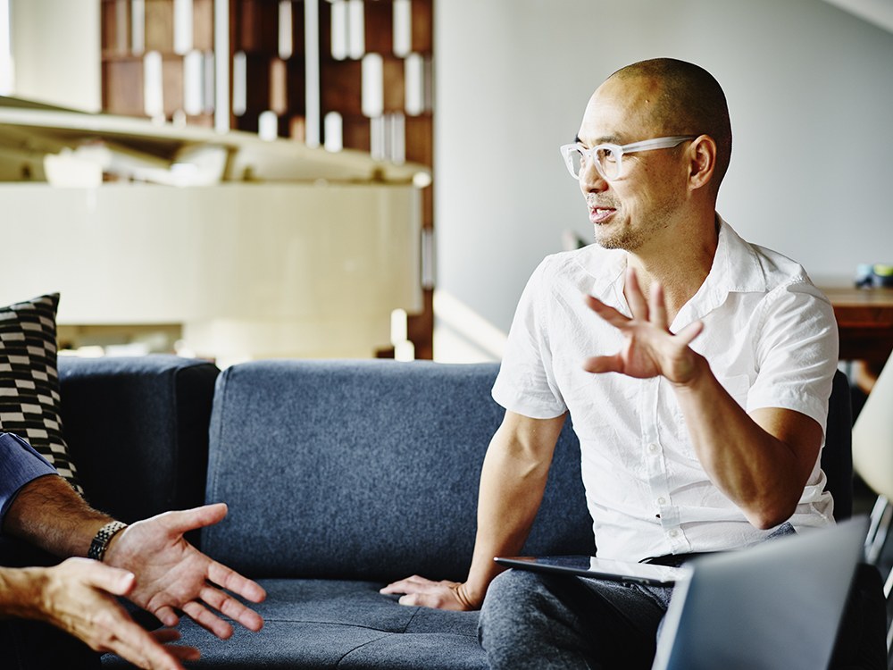 Man in white having a discussion with a team member