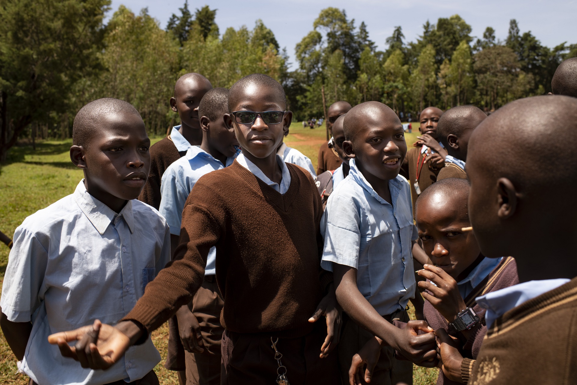 Visually impaired pupil with other kids playing in the backyard of primary school