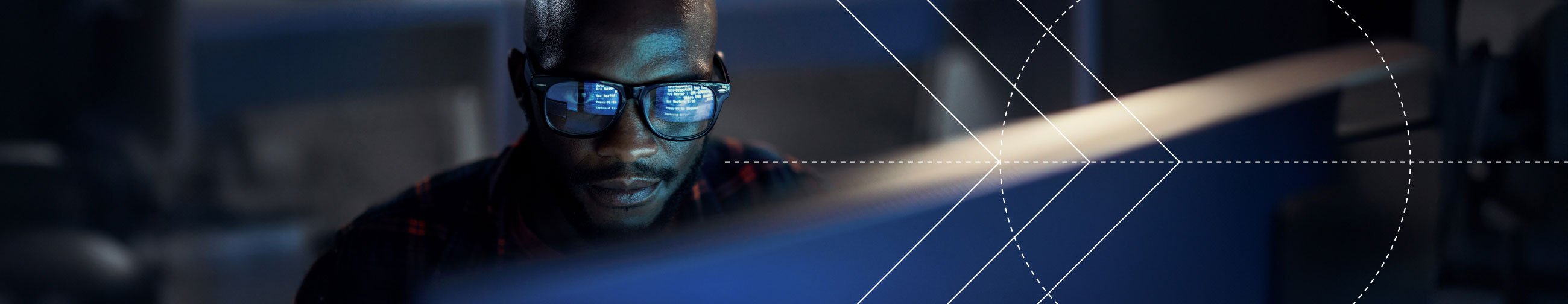  Portrait of a man with computer readings reflected in his glasses.